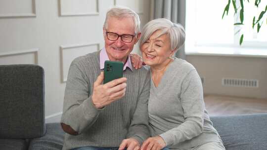 视频通话快乐的高级夫妇女人男人与智能手机