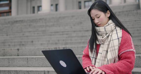 美丽女大学生校园里用笔记本电脑