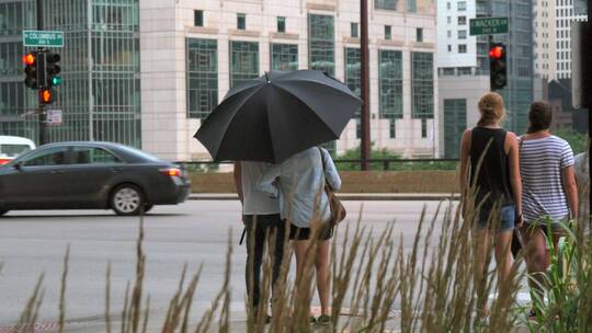 夫妇撑着雨伞站在路边