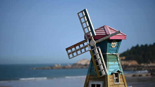 蓝蓝的天空下大海的边上一个木制的风车