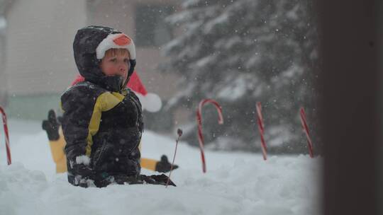 男孩坐在雪地里