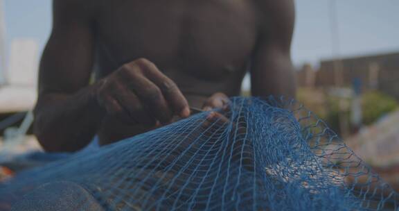 男人在缝补破渔网