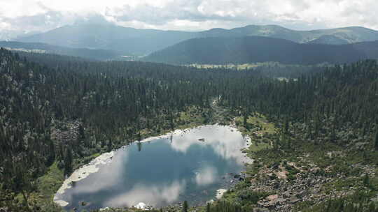 高耸的树木和雄伟的山脉环绕着雄伟的湖泊