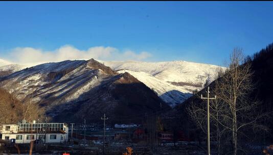 日出时雪山下的村庄与建筑风景