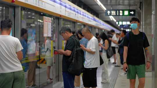 地铁站乘客候车玩手机场景