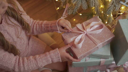 小女孩解开圣诞礼物的蝴蝶结