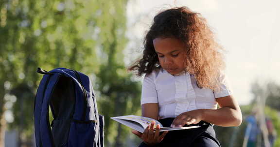 青少年女孩与一本书在的公园