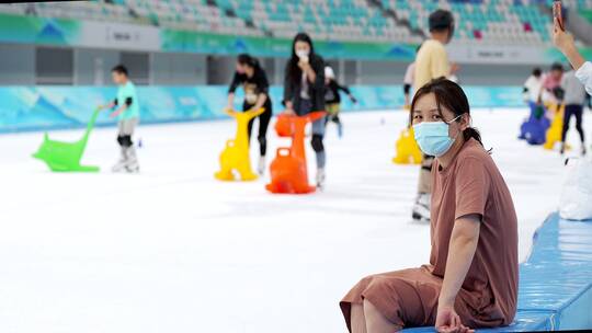 实拍在“冰丝带”国家速滑馆滑冰休息的女性