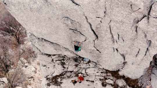 男子攀岩，而另一名登山者正在从空中固定绳