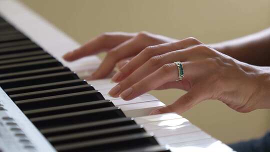 一个女人在明亮的房间里玩合成器。特写