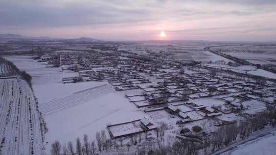 雪后村庄日出时分的壮观景象