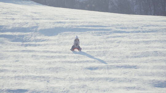 女孩在雪地里骑着雪橇玩耍