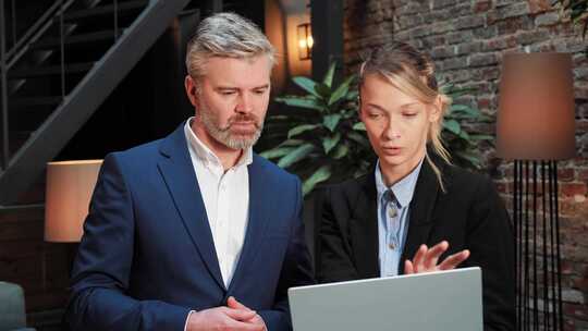 男性和女性用笔记本电脑讨论