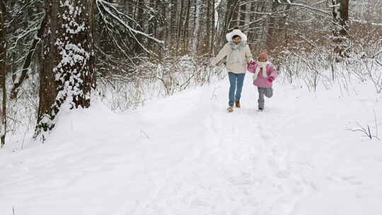 母亲和孩子在雪地里奔跑