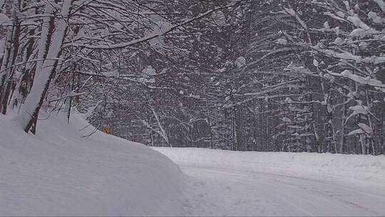 一辆汽车在积雪的山路上行驶