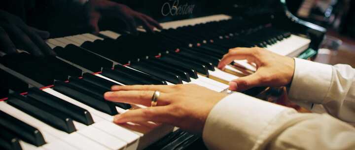 男人的手沿着钢琴键移动