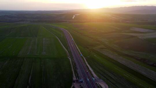 夕阳下航拍穿过麦田的高速公路