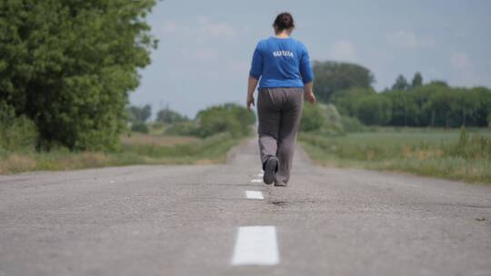 沥青道路上行走的女人