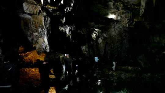 探险家用手电筒探索黑暗的洞穴
