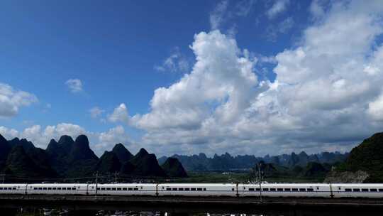 高铁动车列车高铁经过蓝天白云下的山谷乡村