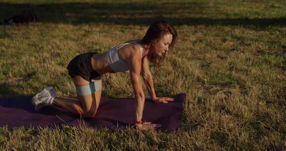 年轻健身女性用阻力带训练臀肌
