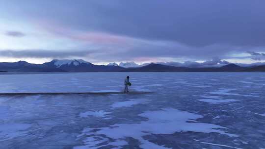 西藏冰面人物与雪山湖泊景观