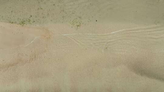 航拍俯瞰威海市环翠区金海路沙滩上的海浪花