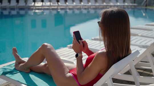 女人，智能手机，日光浴，游泳池