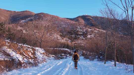 冬日有人在积雪山路行走的景象