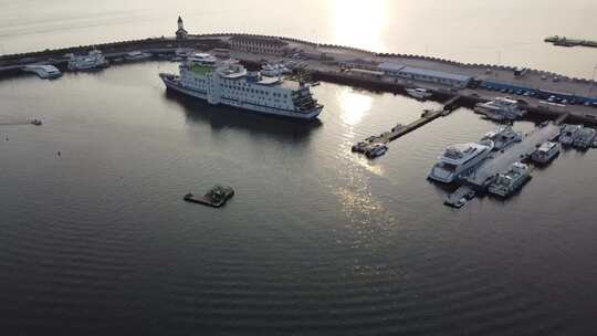 航拍沿海城市海上渔船日落场景