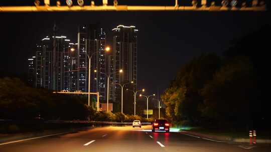 夜间开车行驶在城市道路夜晚城市车窗外风景