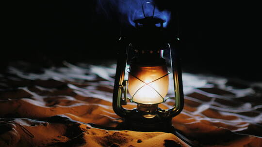 老式油灯在沙滩上发光