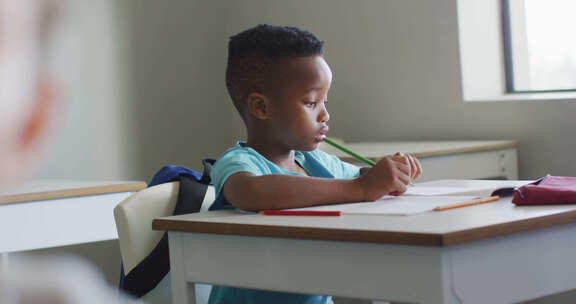 非洲裔美国男孩在教室上课时坐在桌子旁的视频