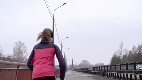 寒冷天气在桥上跑步的女运动员