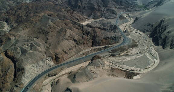 航拍汽车行驶在新疆荒漠沙漠公路