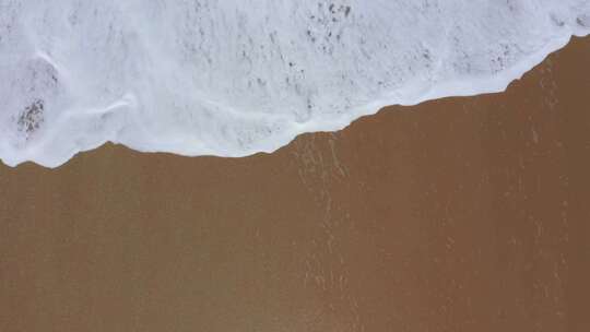 沙滩上的波浪和白色泡沫