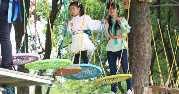 勇敢小女孩系安全带与妈妈高空行走挑战