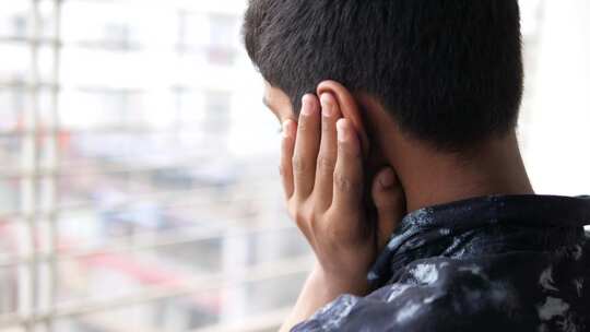 十几岁的男孩耳朵痛触摸他疼痛的耳朵