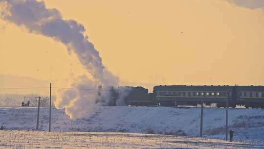 中国东北冬季白雪落日下的蒸汽机车老式火车