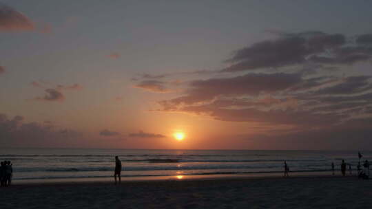 巴厘岛库塔海滩日落，人们行走剪影云天空沙和大海