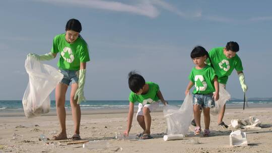 一家四口志愿者在清洁海滩的垃圾亲子活动视频素材模板下载