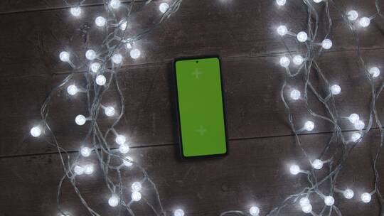 圣诞彩灯环绕的绿幕手机