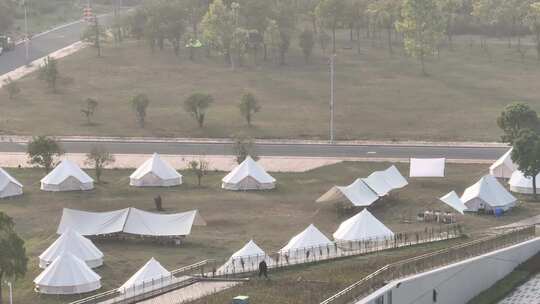 户外草地搭建多顶白色帐篷的景象