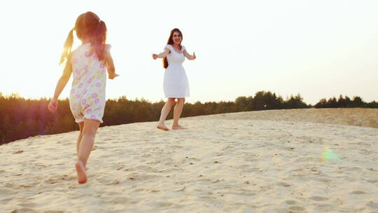 妈妈和一个女孩在沙滩上玩耍