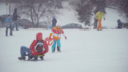 女孩拿着雪橇在雪地里行走