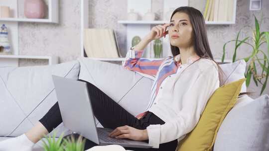 女性沙发上使用笔记本电脑