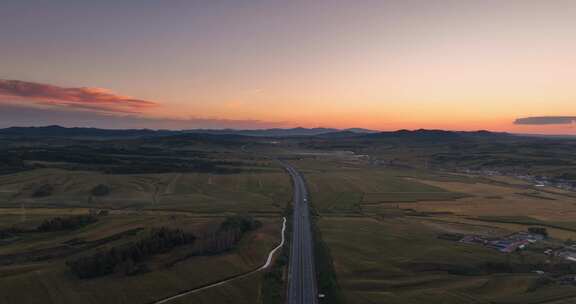 航拍夕阳下穿过草原的高速公路