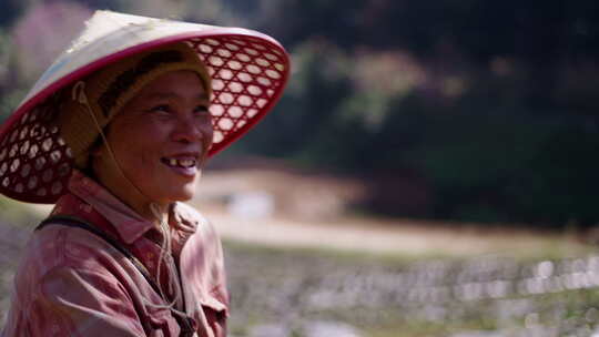 戴帽子的亚洲老年妇女在山中央微笑