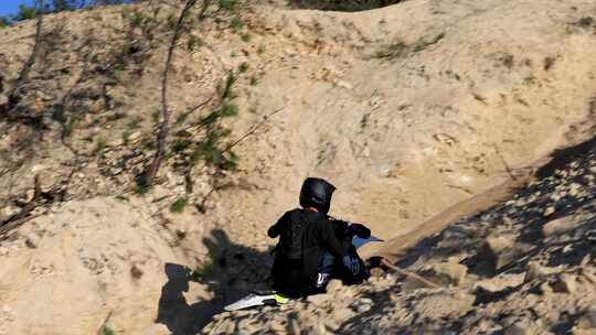 山地越野摩托车骑手黄土坡冲坡到顶