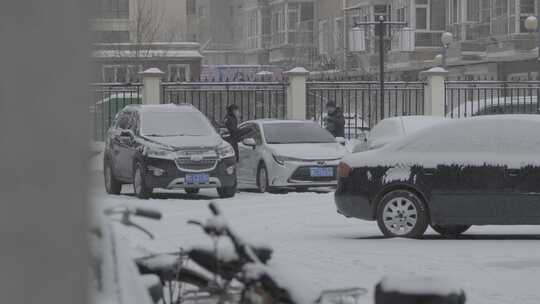 黑龙江牡丹江市小区旁雪中清扫车子积雪夫妻视频素材模板下载